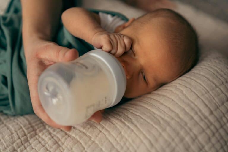 infant drinking from a bottle